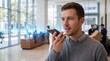 © Curioso.Photography - A businessman uses a smartphone voice assistant inside a modern corporate office lobby.