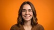 © Abu - Studio close-up portrait of smiling young woman wearing round glasses and warm brown knit sweater against vibrant orange background, natural light and cheerful expression