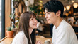 © Jesse_4160 - Young Asian couple in love sitting together inside a cozy cafe, gazing into each other eyes with a romantic and happy expression during a date