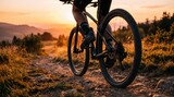 Mountain biker riding bicycle on rocky trail during golden hour sunset, active lifestyle and outdoor adventure sport, cyclist legs and wheels detail, scenic nature with warm
