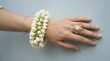 © MDBadrul - Closeup of a womans hand wearing an elaborate jasmine flower bracelet and a vintagestyle ornate gold ring with a large central stone