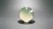 © FarhanaHaque - Minimalist studio still life of clear glass sphere with pale yellow base softly fading into delicate green tones, illuminated by gentle lighting on neutral gray seamless backdrop casting subtle