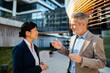 © Davor - Two business professionals discussing outside modern office
