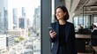 © Eve - Smiling businesswoman using online banking app on smartphone by panoramic office window. Professional financial advisor managing mobile investment, digital transaction, and mortgage payment.
