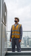 © Rendara Studio - Skilled technician inspecting rooftop air conditioning unit above city skyline