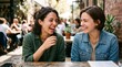 © Lucas - Two happy women laughing together at an outdoor cafe, enjoying each other's company. The sun shines warmly on them, creating a delightful atmosphere