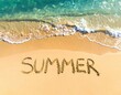 © Zubair - The word 'SUMMER' is written in the sand with the ocean waves gently washing ashore.