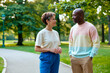 © AnnaStills - Middle aged Caucasian woman and Black man standing in park, conversing during walk and expressing connection and inclusion. Ideal for relationship, diversity, wellness marketing
