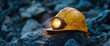 © ajeng - Mining helmet with headlamp on dark rocky surface