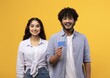 © Prostock-studio - Smiling Young Asian Woman And Man Holding Credit Card While Posing Together In Studio With Vibrant Yellow Background. Excited Young Couple Engaging In Shopping Concept.