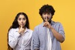 © Prostock-studio - Surprised Young South Asian Man And Woman Making Shushing Gesture While Standing Together Against Yellow Background. They Are Engaging In A Mysterious Action In A Cheerful Mood.