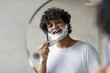 © Prostock-studio - Smiling Young Asian Man Gently Shaving His Facial Hair While Looking At Mirror In Bathroom. Enjoying Personal Grooming Routine At Home, Taking Care Of Appearance And Hygiene.
