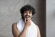 © Prostock-studio - Smiling Young Man With Curly Hair Standing At Home, Posing With Towel On His Neck, Showing Positive Emotion. A Wellness Concept Displaying Confidence And Self-care In A Comfortable Setting.