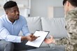 © Prostock-studio - Concerned Black Male Counselor Assisting Young Male Soldier With Paperwork In Modern Office Setting. Providing Guidance And Support During Administrative Process In Healthcare Concept.