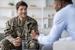 © Prostock-studio - Smiling Young Caucasian Male Soldier Engaging In Conversation With Therapist During Consultation At Office, Promoting Mental Health And Wellness. Focus On Supportive Dialogue And Care.