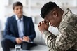 © Prostock-studio - Worried Black Male Veteran Seeking Counseling In Office Setting, Sitting With Hands Clasped, Engaged In Conversation With Therapist. Focus On Emotional Support And Mental Health Awareness.