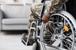 © Prostock-studio - Focused Black Male Adult With Physical Limitation In Wheelchair, Displaying Strength While Sitting In Modern Living Room. Emphasizing Health And Resilience In Daily Life.
