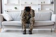 © Prostock-studio - Feeling Stressed. Worried Black Male Soldier Sitting On Sofa At Home, Holding Head In Hands, Reflecting On Emotions And Challenges. Indoor Setting, Mental Health Concept.