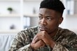 © Prostock-studio - Worried Black Male Soldier Reflecting On Thoughts While Sitting At Home, Wearing Military Uniform. Focused On Personal Matters In A Calm Indoor Setting, Embracing Mental Health Awareness.