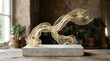© Guilherme - A delicate golden sculpture sits on a concrete base in a room with natural light.
