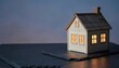 © camo maybe - Miniature wooden house with warm glowing lights inside at night.