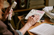 © AnnaStills - Caucasian woman holding landline telephone receiver in retro office, dialing number on keypad. Image represents vintage corporate communication, suitable for nostalgic business marketing