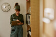 © AnnaStills - Young adult Caucasian woman working in retro office, writing on clipboard near wooden bookshelf. Image suitable for vintage workplace and corporate administration concepts