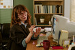 © AnnaStills - Young adult Caucasian woman applying nail polish at desk in retro office, slacking off during work hours. Image represents workplace distraction and is suitable for HR articles