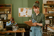 © AnnaStills - Young adult Caucasian woman writing on clipboard while middle aged African American man repairs computer in retro office, representing vintage Information Technology support and technical service