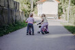 © Katharina - Two little toddler sisters playing together with balance bikes on suburban street