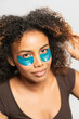 © Gonzalo Infiesta - Young woman applying under eye patches for skincare routine