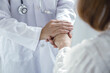 © Orathai - Doctor holding hands of patient to give comfort support and reassurance in hospital clinic for medical healthcare compassion concept