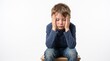 © Cekreks - Sad young boy sitting with head in hands feeling overwhelmed, stressed, or depressed against white background