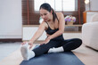 © MINAE - Young asian woman stretching hamstrings on a yoga mat, practicing morning exercise for flexibility and wellness, enjoying a healthy home workout lifestyle