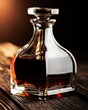 © Aleksey - Elegant glass decanter filled with dark amber whiskey on a rustic wooden bar, illuminated by warm dramatic light for a refined autumn hospitality atmosphere.