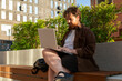 © Danil Nevsky/Stocksy - Student using laptop outdoors on rooftop terrace