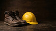 © Dinar - Worn leather work boot and yellow hard hat on wooden surface. Construction safety equipment for labor day. Industrial protection gear for builder job and engineering work concepts.