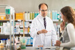 © JackF - Adult man pharmacist offering box of pills to young woman buyer in pharmacy
