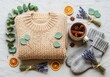 © Boy photographer - A serene flat lay of winter wellness items featuring thick wool knits, a ceramic mug, and herbal elements resting on soft natural linen, mug, soft, candle