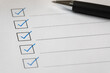 © Anastasiia - A checklist with checked boxes and a pen on white paper, suggesting task completion or review.