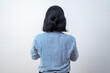 © rizkydionisius - Woman stands backlit, facing a plain white wall