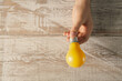 © Artvibe - Woman holding light bulb on wooden background, top view. Alternative energy source