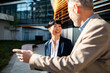 © Davor - Two business colleagues talking outside modern office