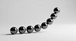 © ShaZett - Minimalist 3D rendering of seven glossy black metallic spheres arranged in an upward curving arc sequence over a light grey surface with soft shadows and studio lighting.