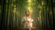© ANIK - Woman meditating peacefully in serene bamboo forest under warm sunlight
