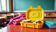 ©  VladaToday - Yellow lunchbox open on a school desk with sandwich, kiwi and apple for healthy kids lunch and classroom meal planning imagery for education and nutrition materials