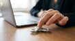 © Yellow Blossom - A woman using a laptop while playing with a fidget spinner on a wooden table in an office.