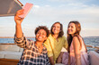 © Westend61 - Friends on a boat trip taking a selfie