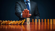 © Asad - Business leadership concept with executive stopping a falling domino sequence using strategic decision making