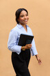 © Mihajlo Ckovric/Stocksy - Hispanic Businesswoman Walks on Sidewalk With Tablet in Her Hand